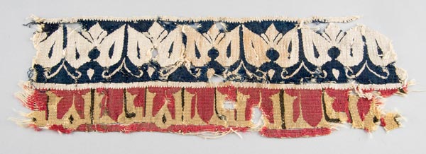 Textile with inscription band and floral designs