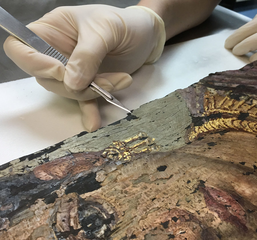 Carrie removes a miniscule paint sample from the Fayum portrait