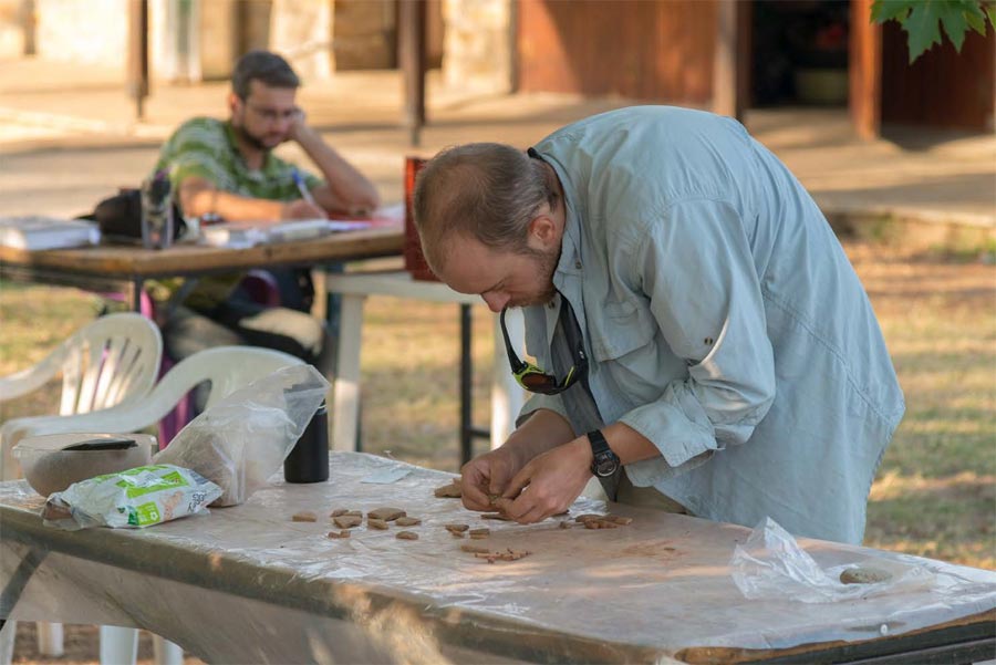 Andrew Cabaniss examining pottery for signs of wear